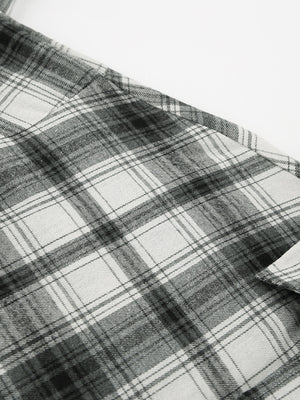 Button-up long sleeve shirt in black and white plaid cotton.