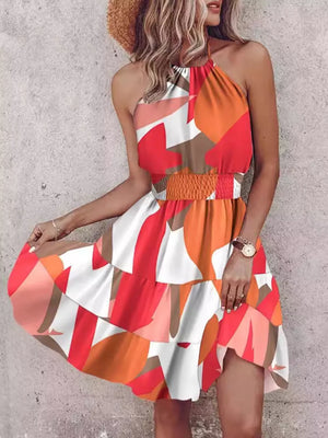 Bohemian halter mini dress with abstract print, smocked waist, and tiered skirt.
