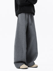 Men's dark gray drawstring wide leg sweatpants with seam detail.