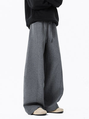 Men's dark gray drawstring wide leg sweatpants with seam detail.