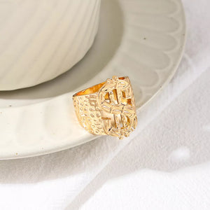 Gold ring featuring dollar sign motif and graphic