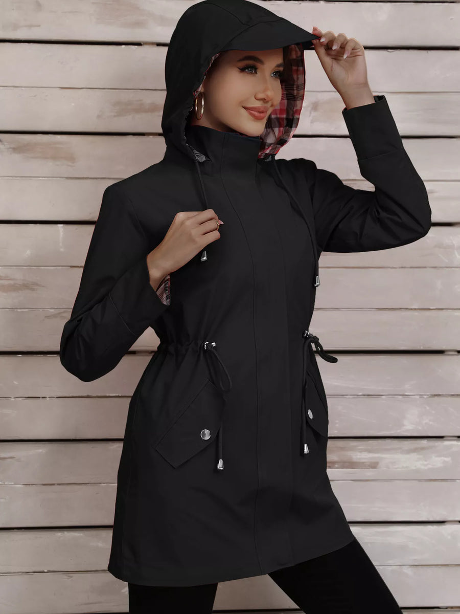 Black drawstring trench coat with plaid lining and snap-down pockets.