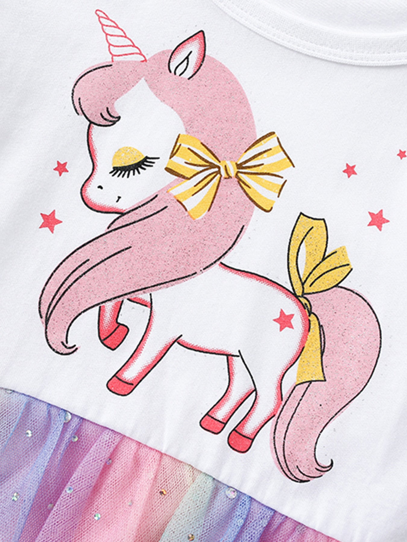 White cotton toddler dress with unicorn graphic, yellow bows, and rainbow tulle skirt.