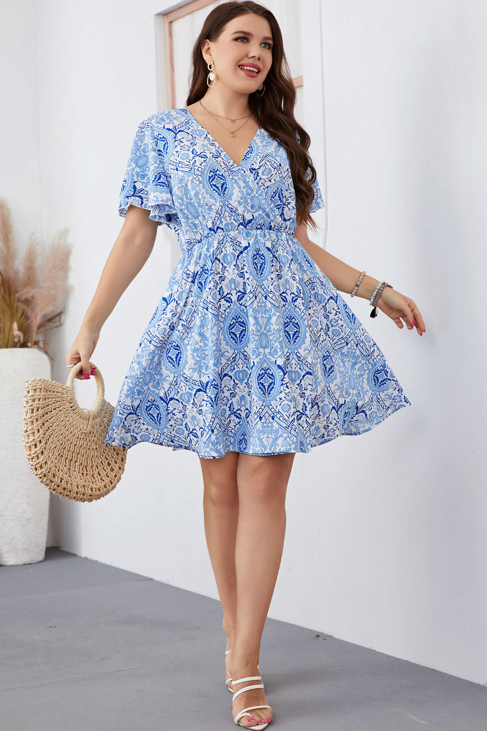 Pastel blue medallion print mini dress with flutter sleeves and a V-neck.