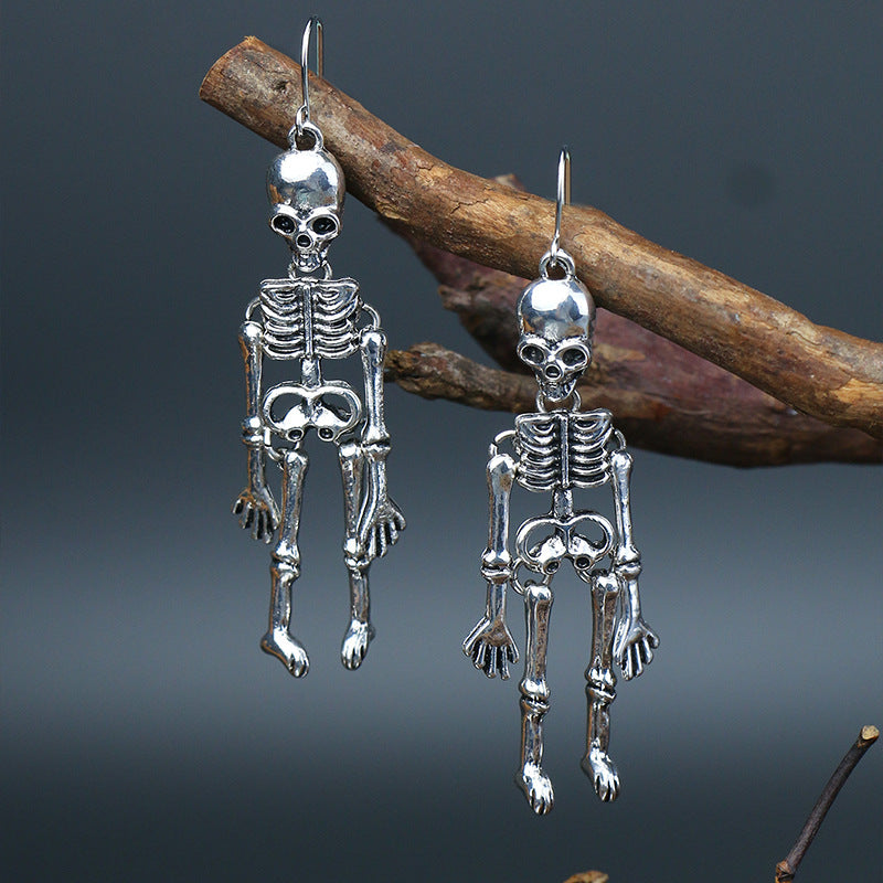 Silver skeleton silhouette drop earrings with detailed bones and skulls.
