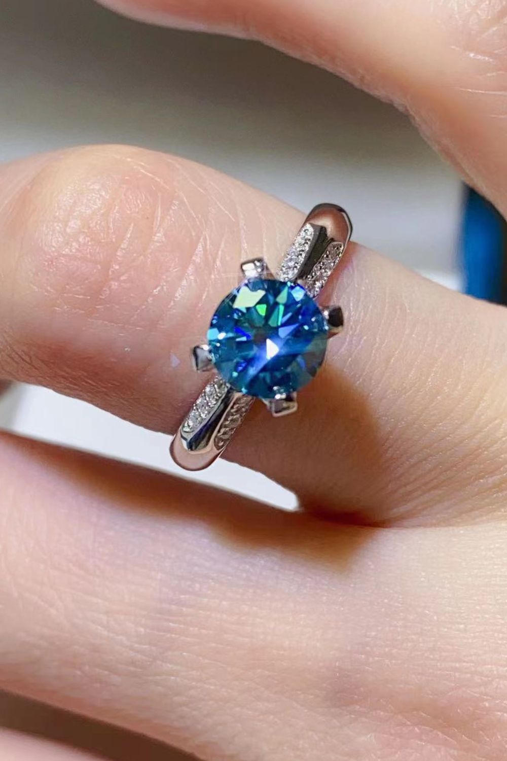 Celestial blue moissanite engagement ring with diamond accents on band
