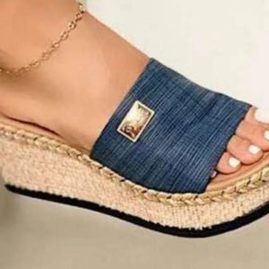 Dark blue textured platform slides with metallic detail and espadrille trim.