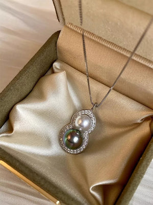 Elegant gourd pendant necklace with pearls and crystals on a box chain.