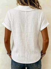 White textured blouse with short rolled sleeves and collared neckline.