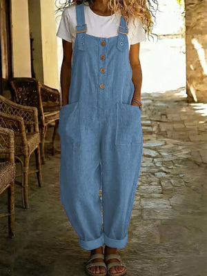 Blue wide leg romper with buttons and pockets, worn with a white tee.