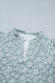 Embroidered floral shirt with ruffled mock neck and V-neck detail.