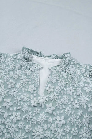 Embroidered floral shirt with ruffled mock neck and V-neck detail.