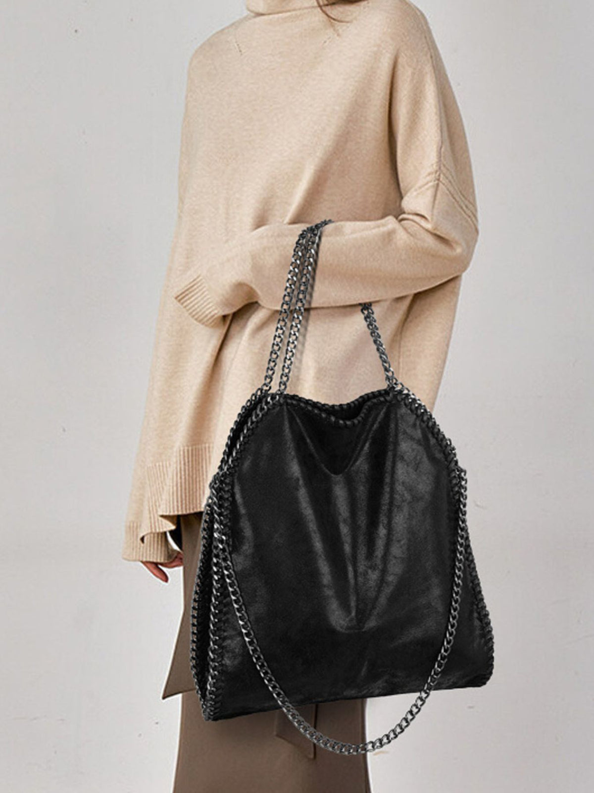 handbag in black featuring chain trim and relaxed fit