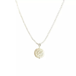 Silver chain necklace with a round, textured pearl pendant.
