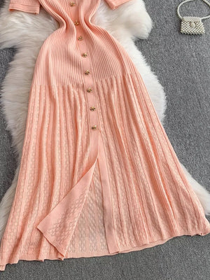 Pink ribbed knit midi dress with gold button detail and open knit skirt panel.