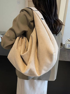 Spacious off-white suede shoulder bag with zipper pocket and slouchy design.