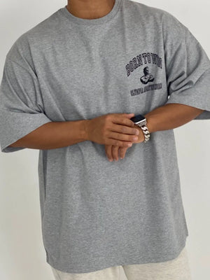 Gray oversized t-shirt with "BORN TO WIN" graphic and short sleeves.