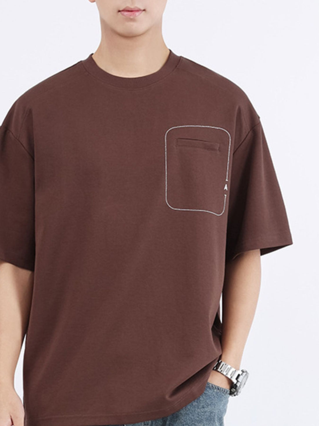 Men's dark brown cotton crew neck t-shirt with decorative pocket detail.