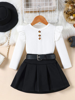 White ruffle sleeve top with button detail and black pleated skirt with belt