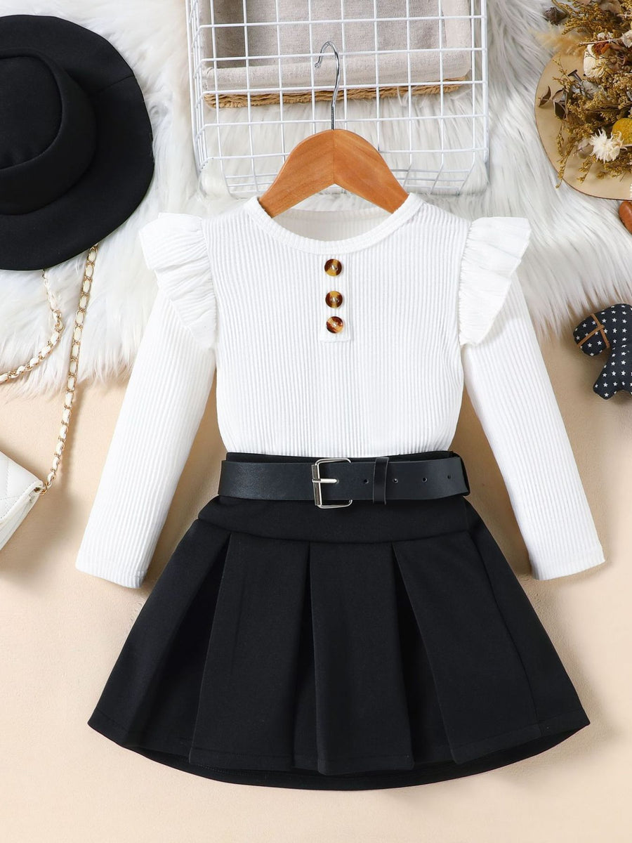 White ruffle sleeve top with button detail and black pleated skirt with belt