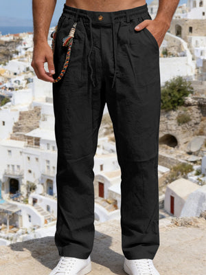 Black linen drawstring pants with elastic waist and decorative braided keychain detail.