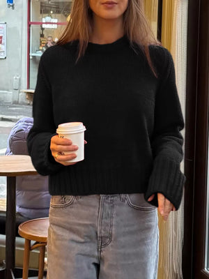 Black ribbed round-neck knit sweater with comfortable fit and wide cuffs.