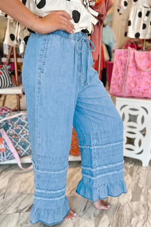 Light wash denim wide leg pants with tiered ruffled hem and drawstring waist