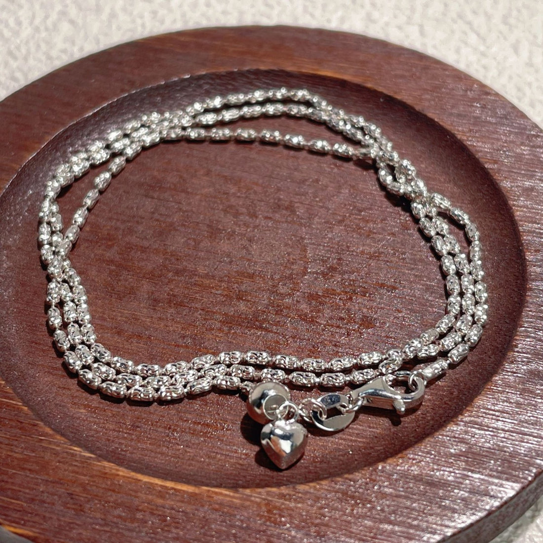 necklace in silver featuring heart charm and layered fit