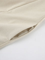 Beige smocked tube dress with zipper detail and pocket.