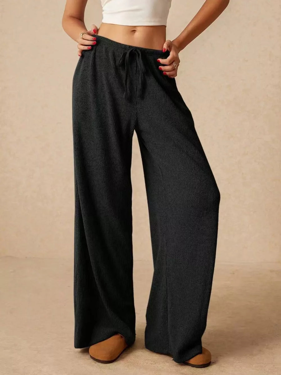 Black ribbed wide-leg drawstring pants with a relaxed fit.