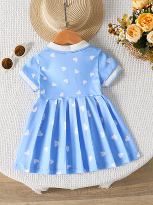 Baby blue dress with white hearts, short sleeves, white collar, and pleated skirt.