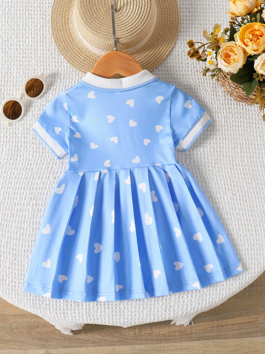 Baby blue dress with white hearts, short sleeves, white collar, and pleated skirt.