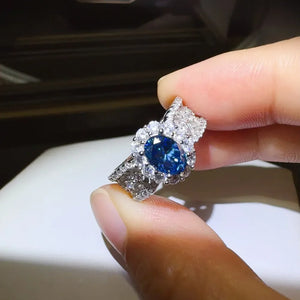 Silver ring with oval blue moissanite and halo of zircon stones