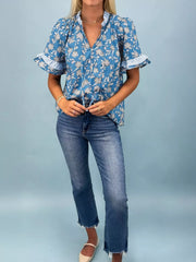 Blue floral cotton blouse with ruffle sleeves and button front.