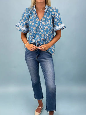 Blue floral cotton blouse with ruffle sleeves and button front.