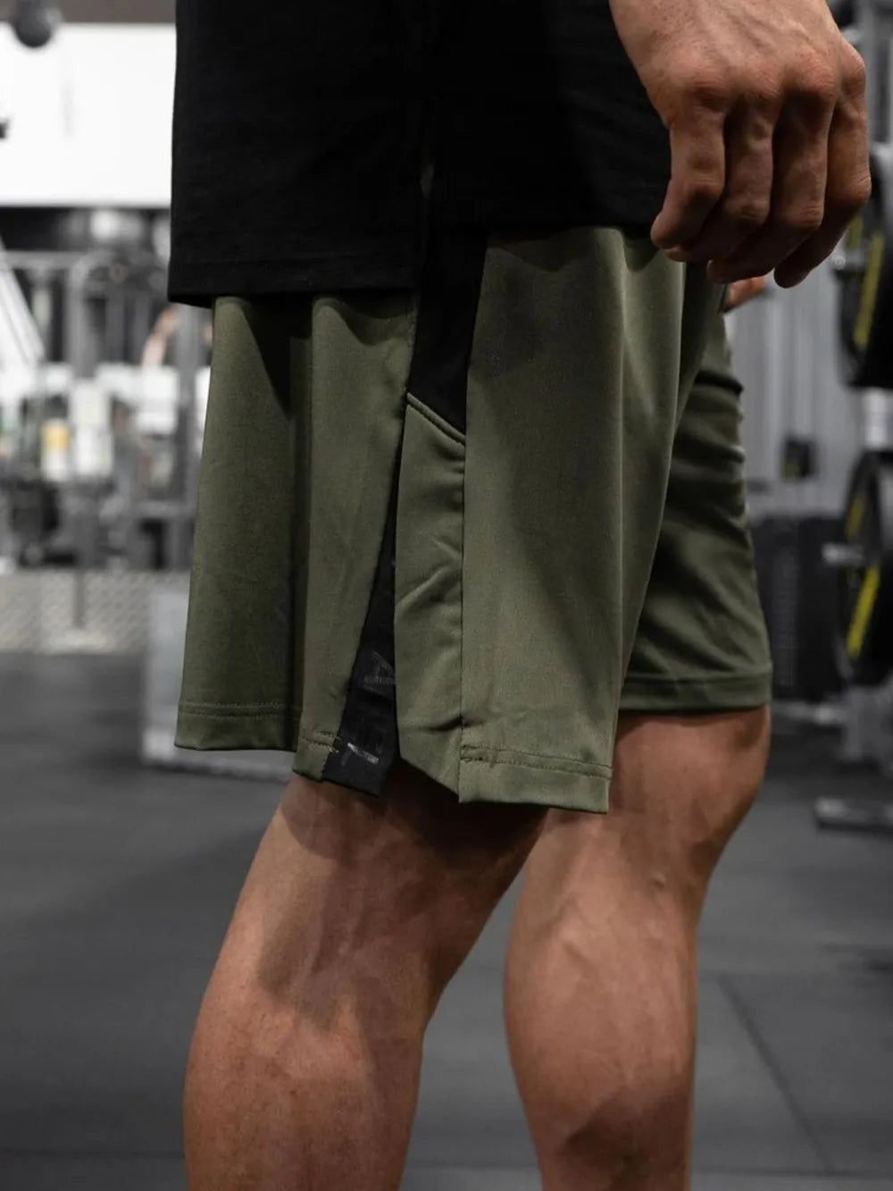 Army green performance shorts with black side panels and logo detail