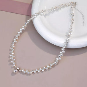 Lustrous irregular pearl pendant necklace with delicate silver accents and a single pearl drop.