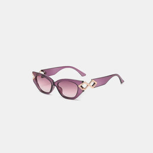 Geometric accent cat-eye sunglasses in purple with gold diamond details.