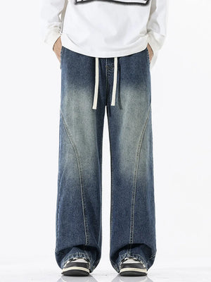 Relaxed fit wide-leg jeans in dark wash denim with drawstring waist and panel detail.