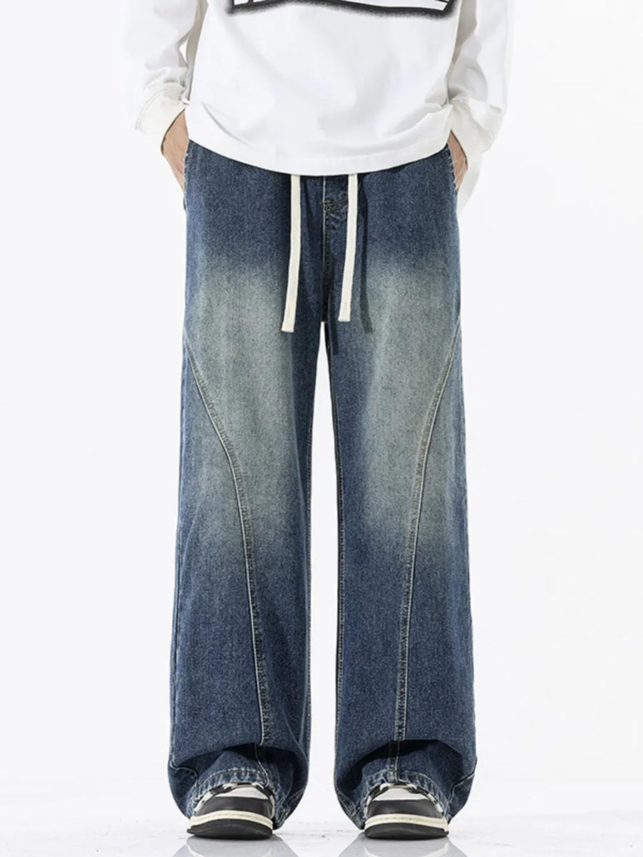 Relaxed fit wide-leg jeans in dark wash denim with drawstring waist and panel detail.