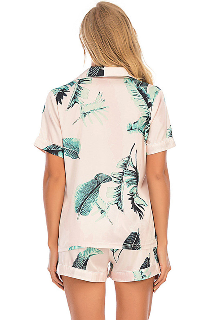 Botanical print satin pajama set in blush pink with short sleeves and shorts.