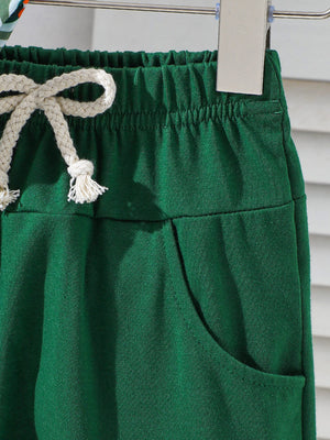 Dark green cotton baby shorts with drawstring and pocket detail.