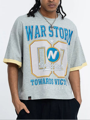 Grey graphic t-shirt with blue and yellow lettering, short sleeves, and yellow trim.