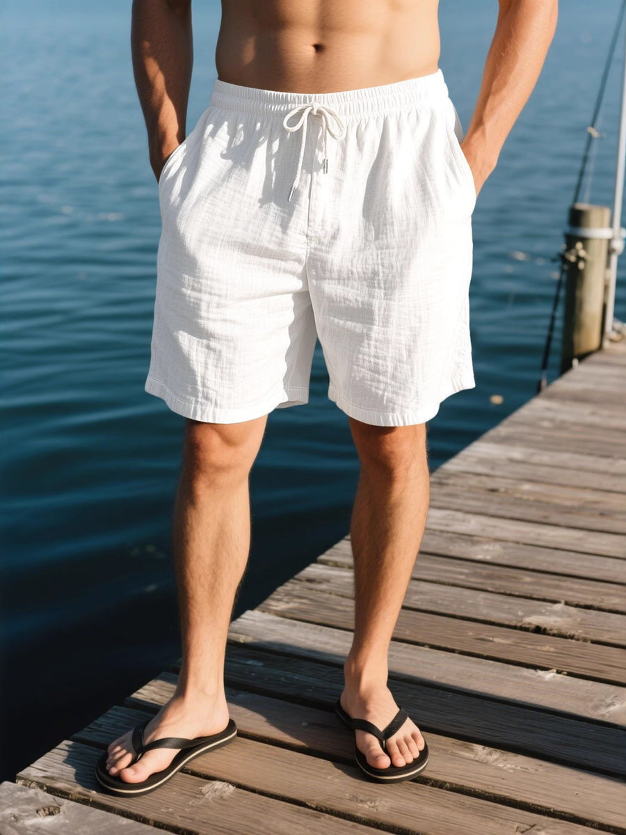 White linen drawstring shorts with pockets and a relaxed fit.