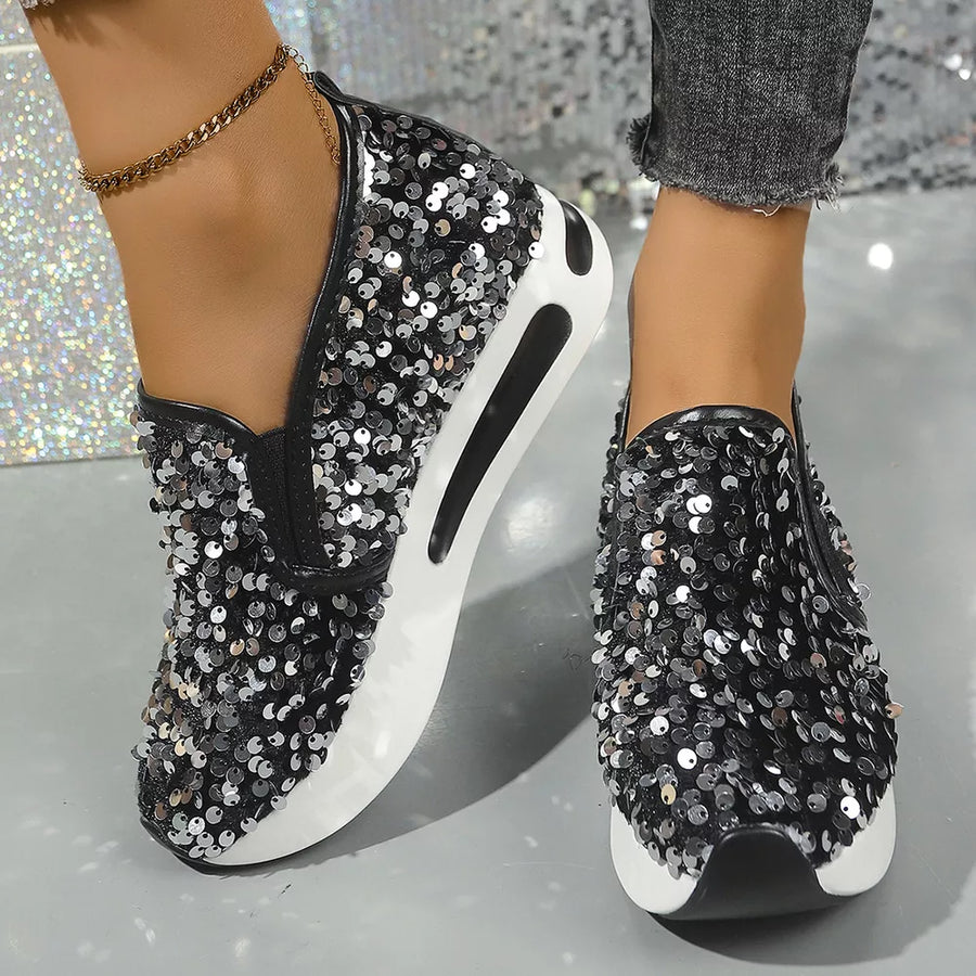 Black sequin slip-on shoes with white soles and black trim.
