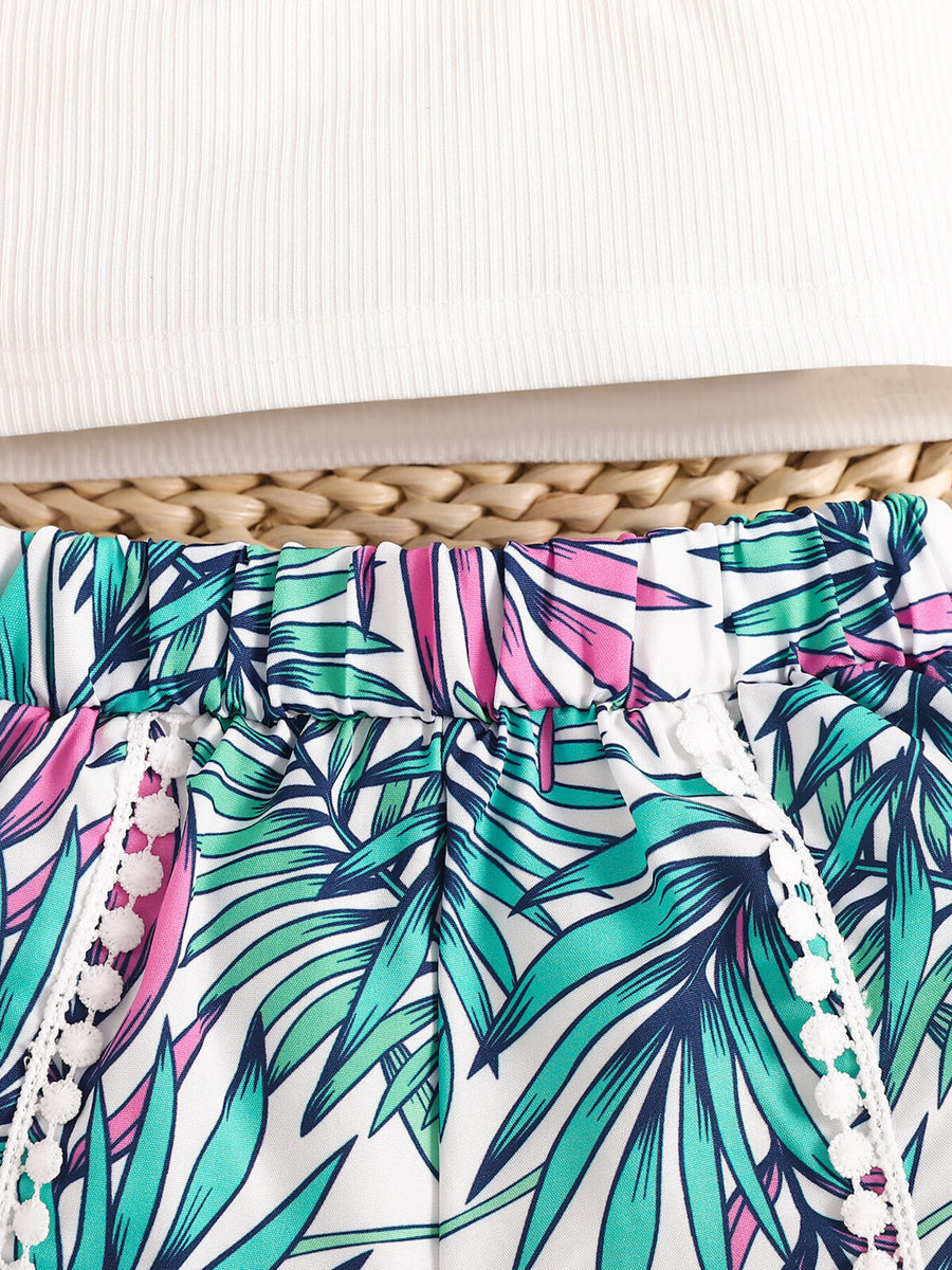 Baby floral shorts with white pom-pom trim and elasticated waist, paired with a white ribbed tank top.
