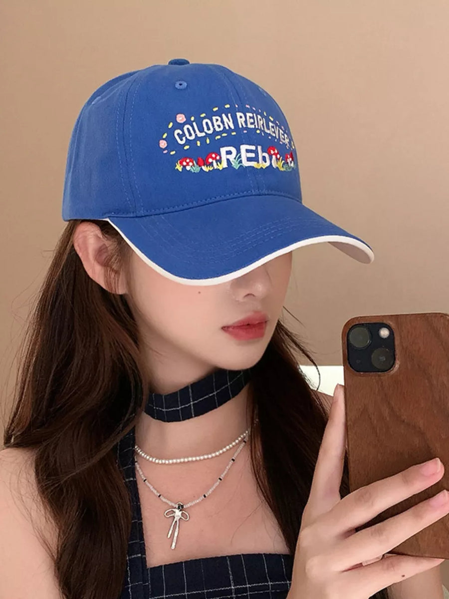 Blue baseball cap with playful embroidered mushrooms and text detail