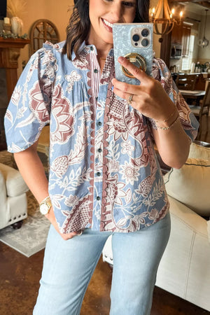 Blue cotton button-up shirt with floral print and scalloped trim.
