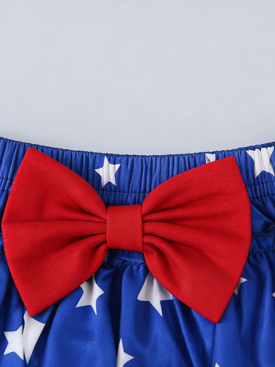 Baby set with red bow and white stars on royal blue cotton blend fabric.