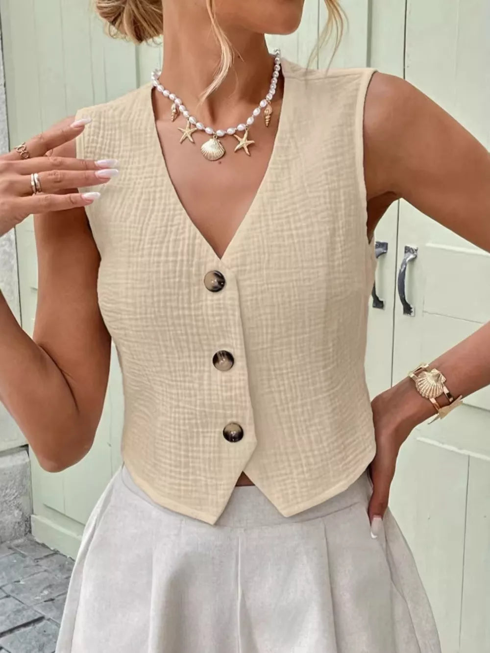 Textured apricot cotton button vest with V-neck and cropped length.